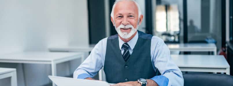 AI Adoption, Portrait of modern senior business man using laptop. Looking at camera.